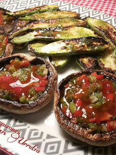 Una foto de Champiñones rellenos de sofrito, y calabacines con aceite de ajos y pereji