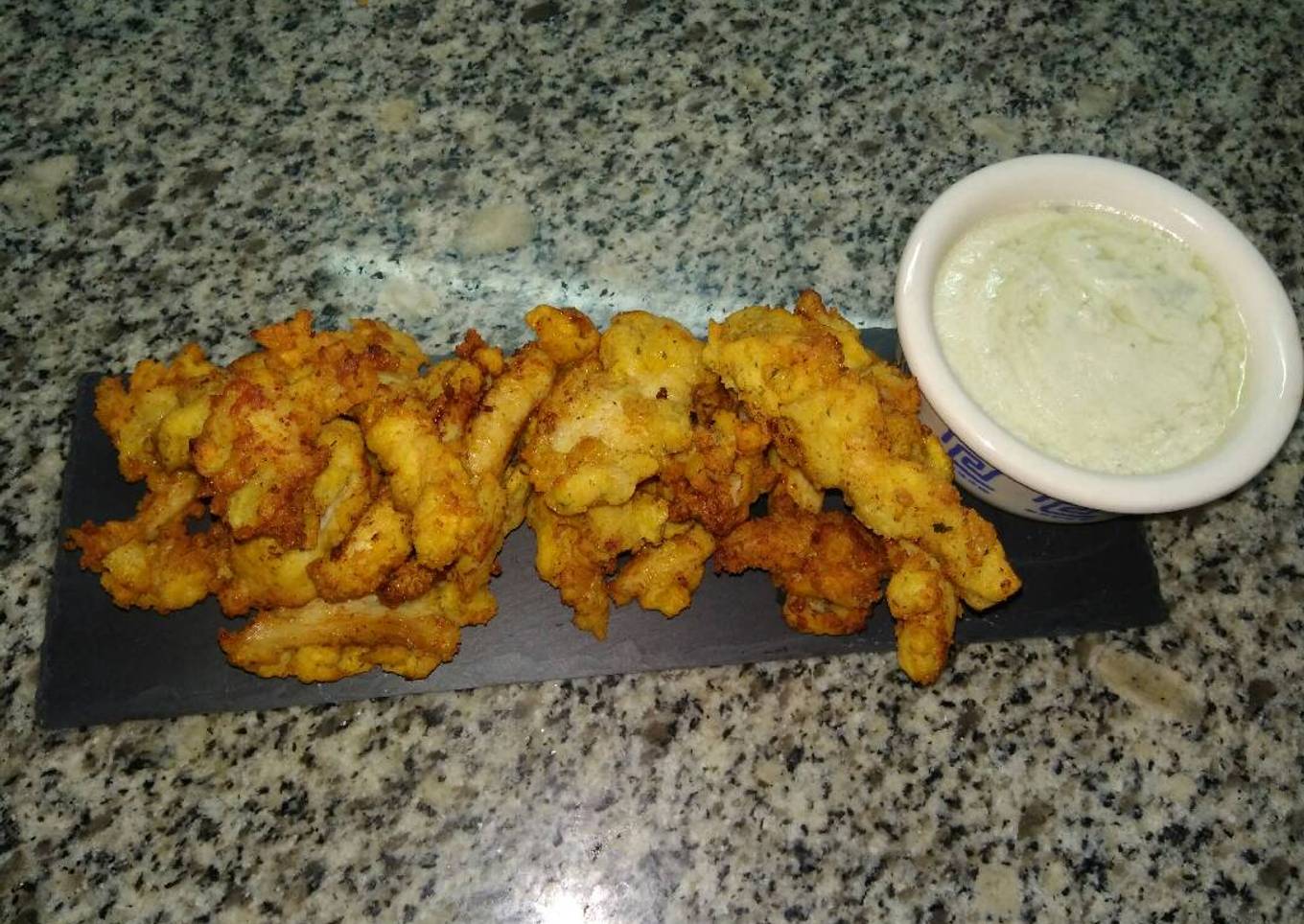 Tiras de pollo rebozado con pan y patatas chips