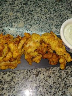 Una foto de Tiras de pollo rebozado con pan y patatas chips