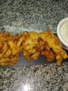 Una foto de Tiras de pollo rebozado con pan y patatas chips