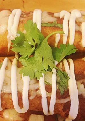 A picture of Shredded Pork Mole Enchilladas.