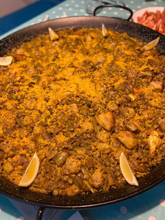 Una foto de Paella con alcachofas, habas y ajos tiernos, carne y albondiguitas