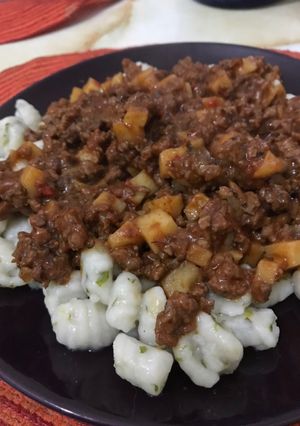 Una foto de Ñoquis de perejil con Bolognesa