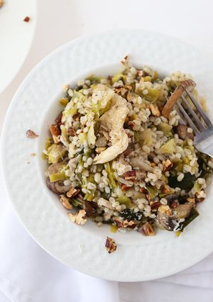 A picture of Toasted Barley Pilaf with Mixed Mushrooms and Leeks topped with Manchego Cheese and Toasted Walnuts.
