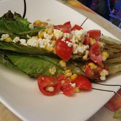 A picture of Grilled Hearts of Romaine with Tomato and Corn.