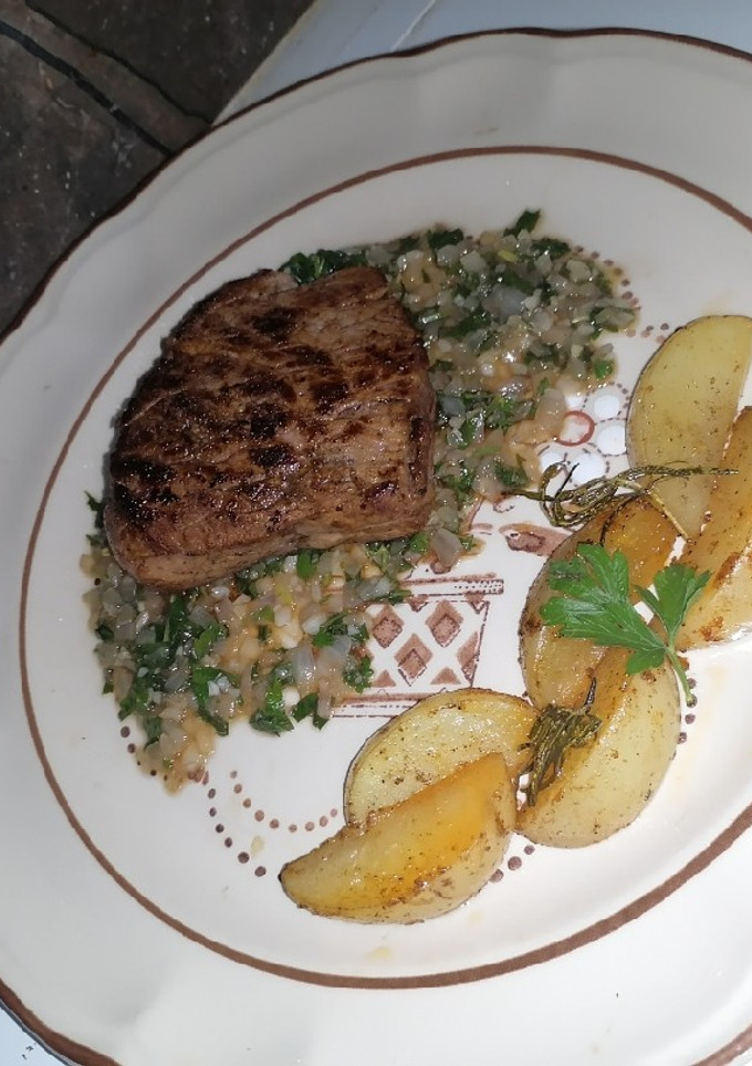 Una foto de Filete al perejil con papas rústicas