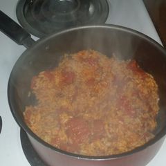 A picture of Spicy yellow rice with diced tomatoes.
