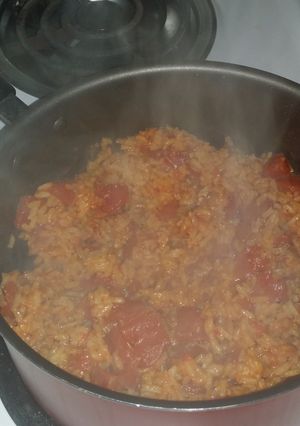 A picture of Spicy yellow rice with diced tomatoes.