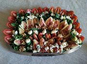 Una foto de ensalada de can higos rúcula
