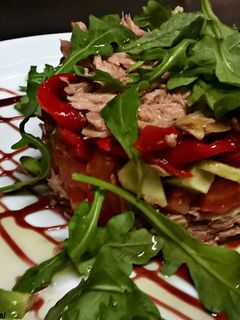 Una foto de Ensalada de pimientos del piquillo, con atún, aguacates, y rúcula