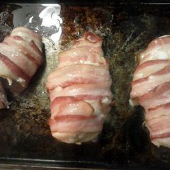 A picture of Bacon wrapped chicken stuffed with ham and cheese.