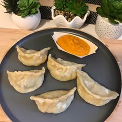 A picture of Chicken Momos with Momos Chutney.