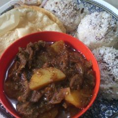 A picture of Beef and topiaco curry with rice coconut cakes.