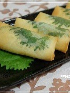 A picture of Spring Rolls Filled With Chicken Tenders and Cheese, Accented with Shiso.