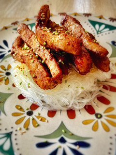 Una foto de Timbal de lomo caramelizado sobre noodles glass