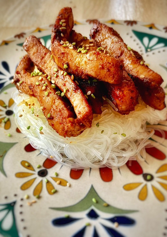 Una foto de Timbal de lomo caramelizado sobre noodles glass