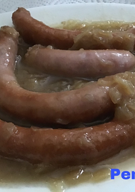 Una foto de Salchichas con cebolla caramelizada al vino blanco envejecido