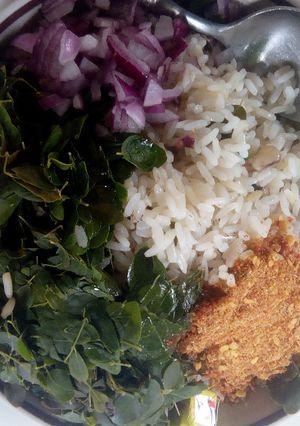 A picture of Rice and beans with moringa leaves.