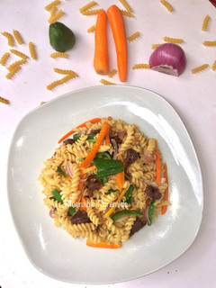 A picture of Fusilli and lamb chops stir fry.