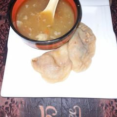 A picture of Chicken dumplings with hot and sour soup.