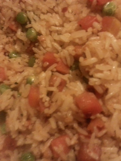 A picture of Spicy garlic rice with peas and carrots.