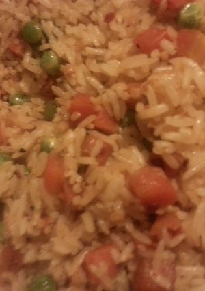 A picture of Spicy garlic rice with peas and carrots.