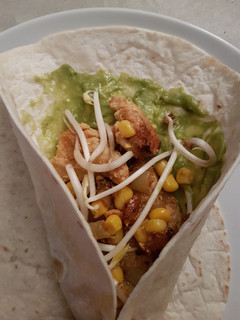 Una foto de Fajitas de pollo, cebolla, pimiento, maíz y soja con guacamole
