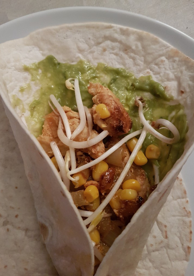 Una foto de Fajitas de pollo, cebolla, pimiento, maíz y soja con guacamole