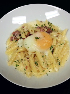 A picture of Penne' Pasta with back bacon white sauce and poached egg.
