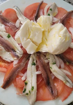 Una foto de Ensalada de verano de tomate, mozzarella anchoas y boquerones en vinagre
