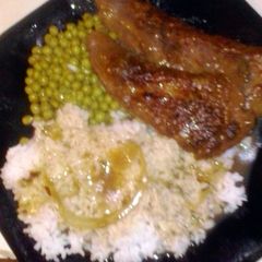 A picture of Liver & Onions with Rice gravy & Green peas.