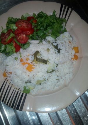 A picture of White rice,carrot,peas,cucumber, with lattuce,.