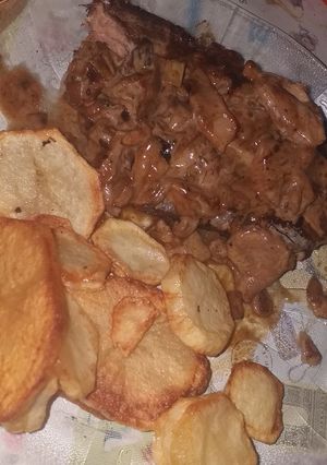 Una foto de Corte americano con salsa de champiñón y papas fritas