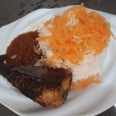 A picture of Boiled rice with sauce and fried titus fish.