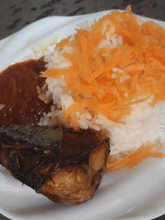 A picture of Boiled rice with sauce and fried titus fish.