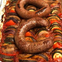 A picture of Farm shop wild boar and venison sausages on ratatouille.