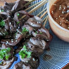 A picture of Chicken heart kebabs with peanut satay dip.
