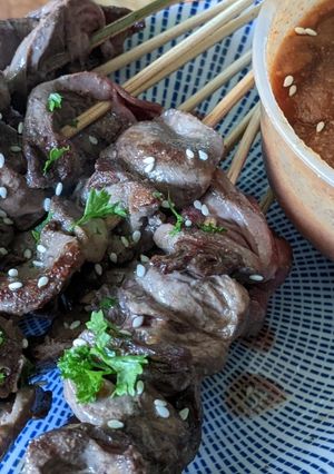 A picture of Chicken heart kebabs with peanut satay dip.