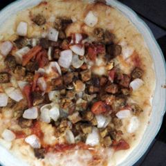 A picture of microwave chicken tikka pizza.