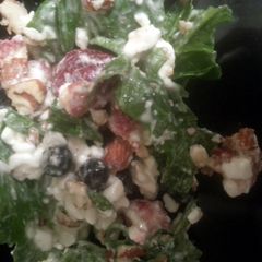 A picture of spinich, berry, nuts, and cheese salad..