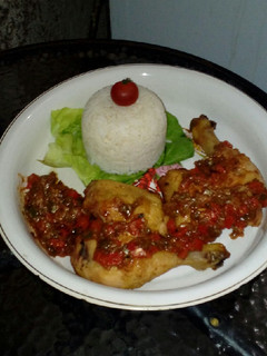 Una foto de Muslos de pollo con salsa y timbal de arroz