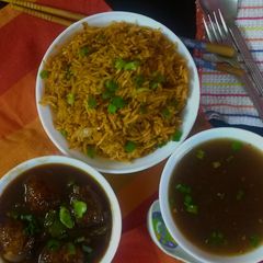 A picture of Chainese manchurian with soup and fried rice.