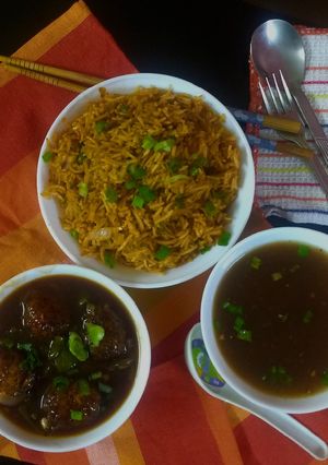 A picture of Chainese manchurian with soup and fried rice.