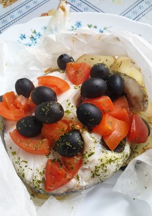 Una foto de Merluza en papillote con aceitunas negras y tomate