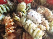 Una foto de pasta al pesto con tomates cherry