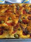 Focaccia con pomodorini olive capperi e acciughe