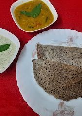 A picture of Ragi dosa with sambar and chutney.