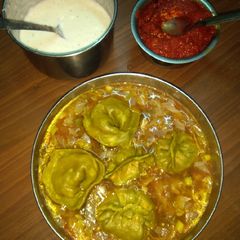 A picture of Spinach momos with gravy.