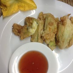 A picture of Cheese stuffed pumpkin flowers with sweet chilli sauce.