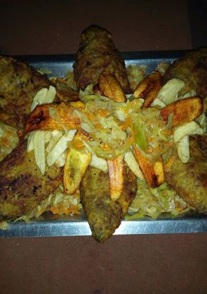 A picture of Fried fish with plantain and cabbage sauce.